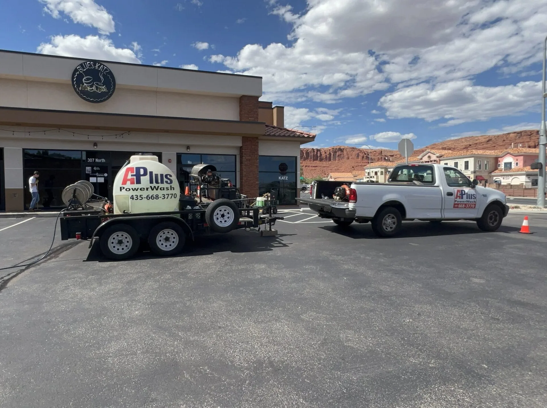 A-Plus Power Wash truck and trailer parked at a commercial job site with Southern Utah red rocks behind