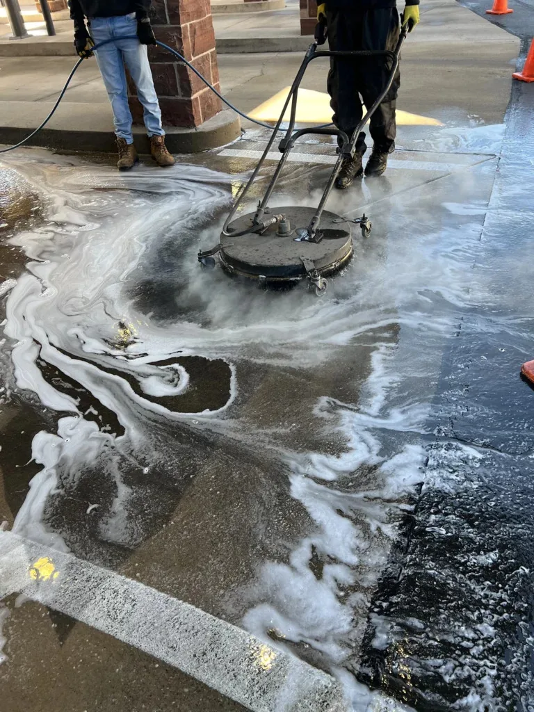 Industrial surface cleaner moving through foam on a commercial concrete surface