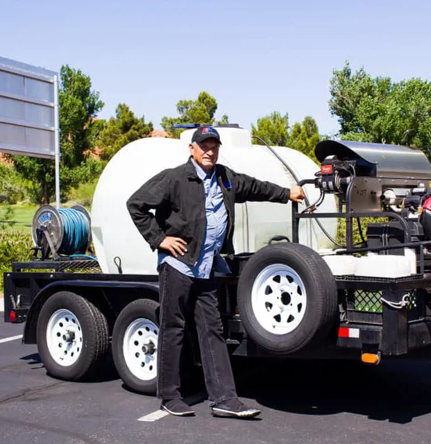 A-Plus Power Wash owner standing beside a professional pressure washing trailer