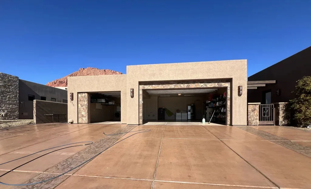 Clean stained concrete driveway at a modern home with red rock mesas in the background